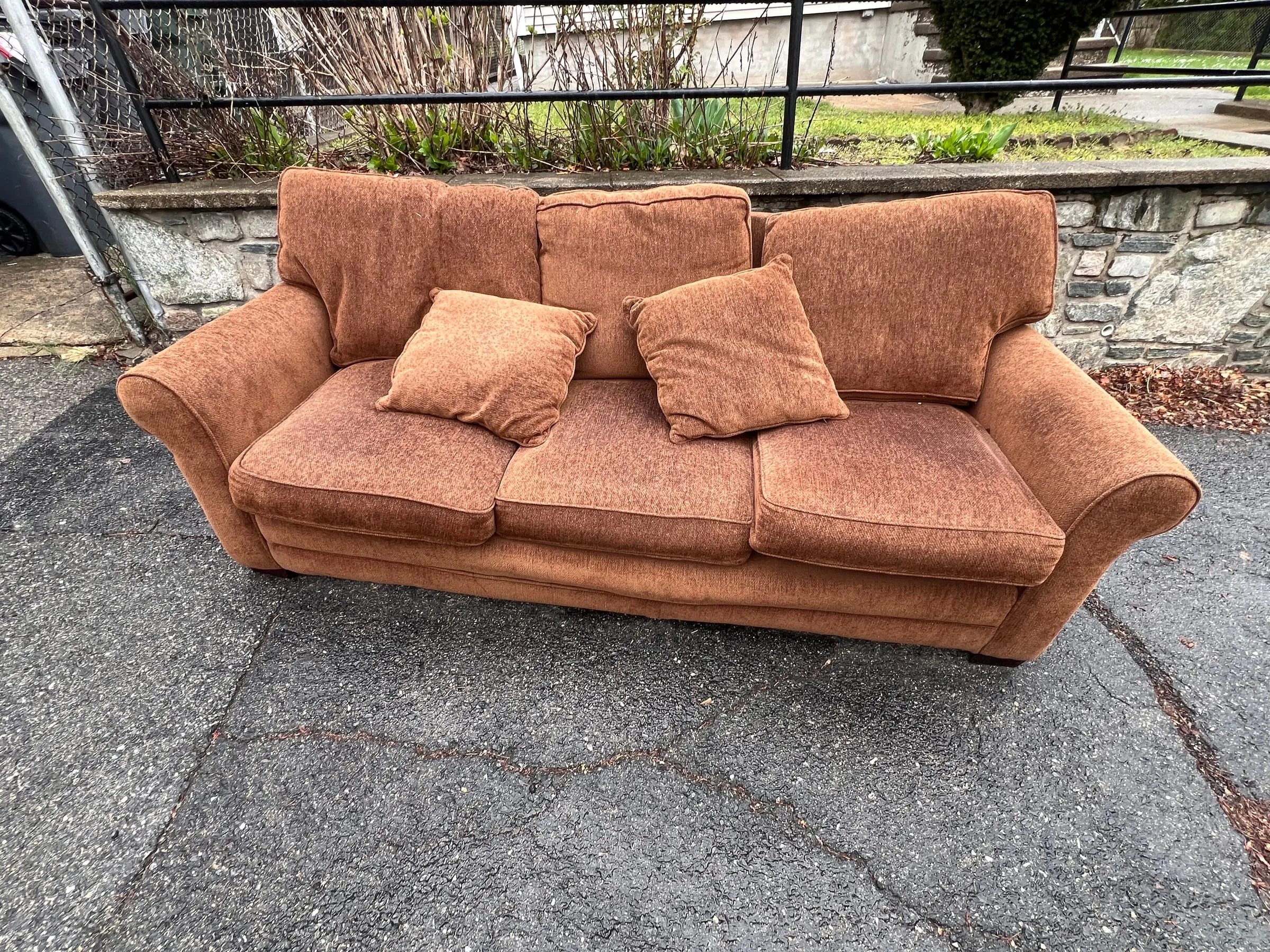 A worn couch left at the curb